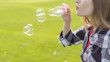 © Freepik - Side view blonde girl making soap bubbles