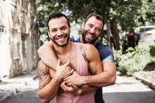 A Portrait Of A Happy Gay Couple Outdoors In Urban Background
