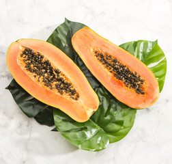 Wall Mural - Close-up papaya on monstera leaf