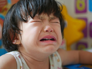 Crying Asian baby girl, two years old, with tears - selective focus and close up shot