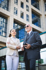 Canvas Print - An older man and a young colleague are talking about work