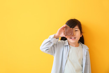 Canvas Print - Funny little girl holding tasty toast with chocolate spreading on color background