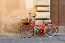 Red Classic Model Women's Bicycle With A Lock Parked Against The Wall In The Italian City Of Foligno.