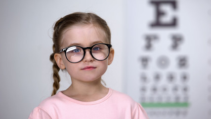 Poster - Adorable happy girl wearing glasses for better vision, comfortable eyewear