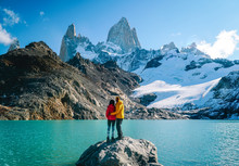 Couple In Love At Mount Fitzroy. Scenic View Of Snowcapped Mountain Tops Of Patagonia Trek. Blue Sky, Turquoise Lake And Scenic Rock Landscape. Shot In Argentina. Nature, Travel, Adventure, Hiking.