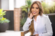 © elnariz - Home living lifestyle portrait of multiethnic hispanic woman sitting on patio outdoors on sunny day