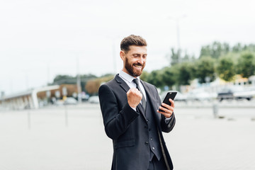 Dance success. Successful confident businessman celebrates his success. Young man formal wear his hands up and rejoice.