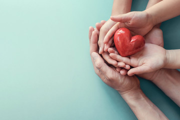 family hands holding red heart, heart health insurance, charity volunteer donation, csr responsibili