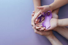 Adult And Child Hands Holding Purple Ribbons  On Purple Background, Alzheimer's Disease, Pancreatic Cancer, Epilepsy Awareness, World Cancer Day, Domestic Violence Awareness Concept