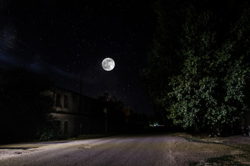 Wall Mural - full moon over quite village at night. beautiful night landscape of old town street with lights. rus