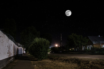 Wall Mural - full moon over quite village at night. beautiful night landscape of old town street with lights. rus