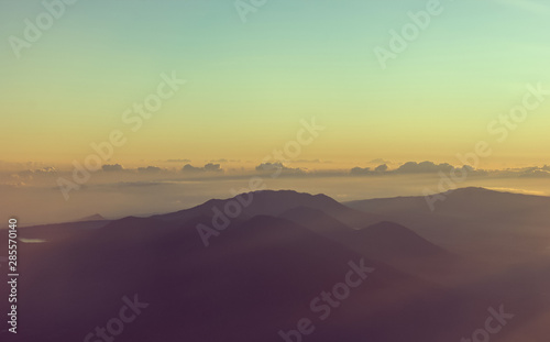 Fotografía Mountains on the horizon view from a plane at sunrise with the colors of the sky
