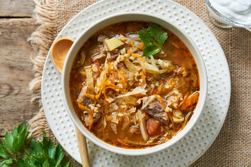 Wall Mural - Traditional russian cabbage soup with meat in a white bowl 