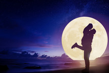 Young Couple Kissing On Beach And Watching The Moon.Celebrate Mid Autumn Festival