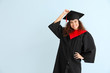 © Pixel-Shot - Young African-American student in bachelor robe on color background