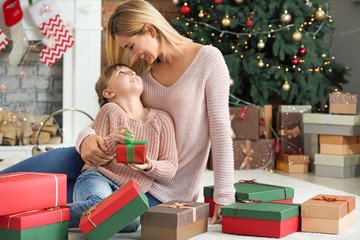 Wall Mural - Cute little girl and her mother with Christmas gifts at home