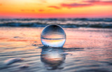 Fototapeta  - Beautiful sunset on the beach in Slowinski National Park near Leba, Poland. View through a glass, crystal ball (lensball) for refraction photography. Wild, untouched nature.