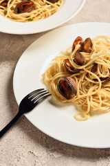 close up view of delicious pasta with seafood served in two white plates with fork