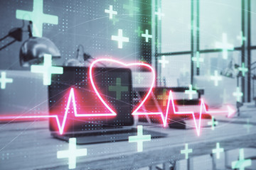 Heart hologram with desktop office background. Double exposure. Concept of medical education