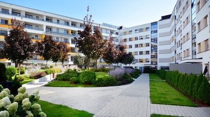 Contemporary residential building exterior in the daylight. Modern apartment buildings on a sunny day with a blue sky. Facade of a modern apartment building