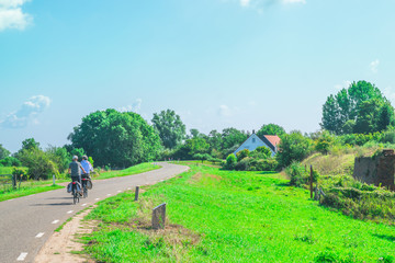 Two unidentified people cycling on path