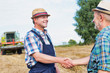 © MDBPIXS - Mature farmer hand shaking senior farmer in field