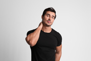 Wall Mural - Portrait of handsome young man in black t-shirt on grey background