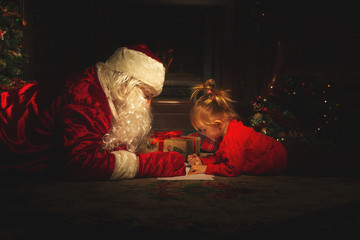 Real Santa Claus is playing with children near the Christmas tree.