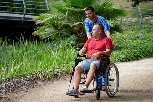 Fotomural disabled man in a wheelchair talking with his caretaker