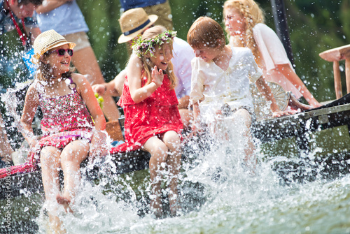 Cuadros en Lienzo Photo of mother playing water with kids in lake while sitting on pier against fa