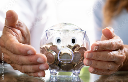 Cuadros en Lienzo Human Hand Protecting Piggy Bank