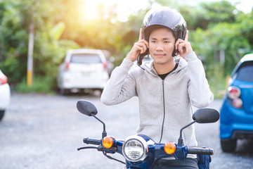 Before riding a motorcycle, a handsome Asian man wore a helmet. road safety