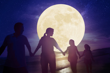 family walking on beach and watching the moon.Celebrate Mid autumn festival concept