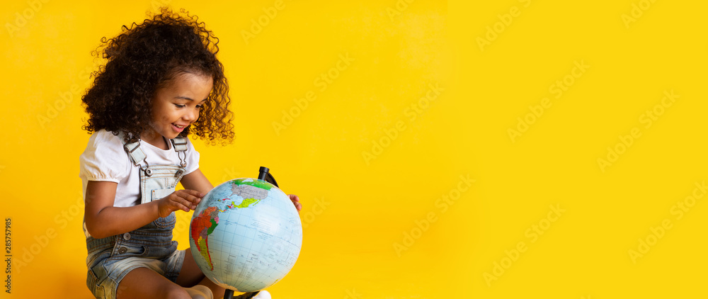 Early education. Little girl pointing to world globe - obrazy, fototapety, plakaty 