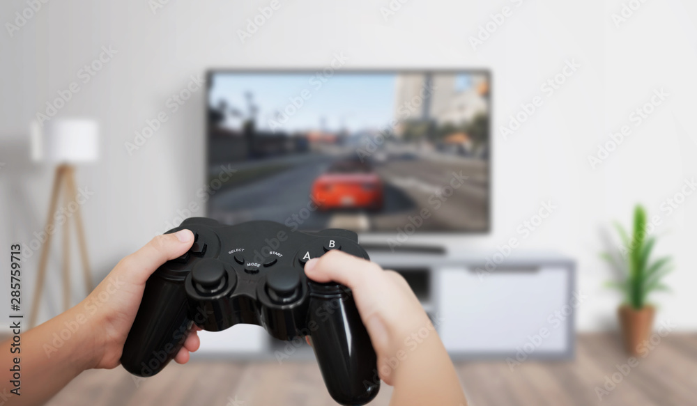 Boy play game on large TV in living room. Concept of digital entertainment, gaming industry. - obrazy, fototapety, plakaty 