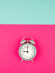 Flat lay with vintage alarm clock over the pastel background