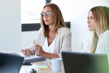 Wall Mural - Two concentrated business woman listening her partners on coworking space.