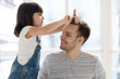 © fizkes - Cute funny kid daughter playing with father brushing hair