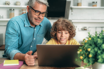 Wall Mural - Father and kid looking on laptop display