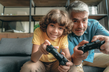 Canvas Print - Mature father with son playing in video games