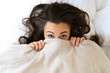 © Yakobchuk Olena - Cute young woman hiding face under blanket