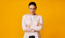 Angry Young Woman Frowning Crossing Hands On Yellow Background
