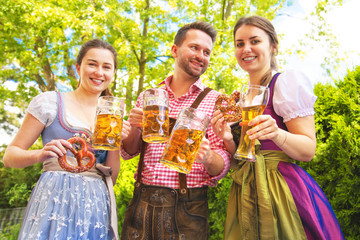 Wall Mural - Young people in Tracht, Dindl and Lederhosen having fun in Beer garden