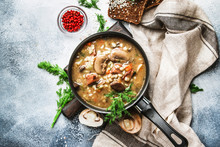 Autumn Or Winter Meat Vegetable Mushroom Hot Soup With Beef And Wholegrain Barley. With Black Breaв And Parsley, Top View, Gray Kitchen Table, Copy Space