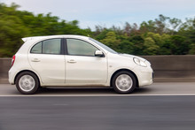 White Car Rides On Highway With Background Blurred Of Motion.