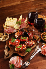 Italian antipasti wine snacks set. Cheese variety, Mediterranean olives, Prosciutto di Parma, tomatoes, artichokes