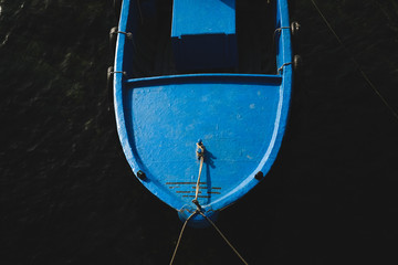 Blue wooden boat on dark blue water