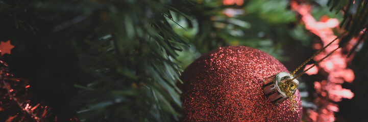 Red christmas ball hanging on decorated tree