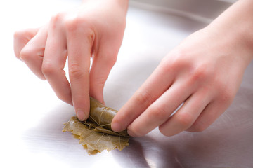 colse up for hands making stuffed leaves