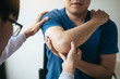 © wutzkoh - Physical therapists are checking patients elbows at the clinic office room.